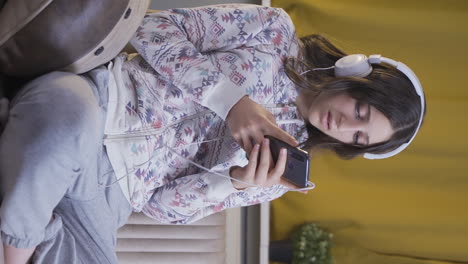 Vertical-video-of-The-young-woman-texting-on-the-phone-at-night-is-unhappy-and-sad.